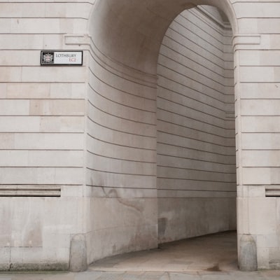A light-coloured stone archway with a street sign