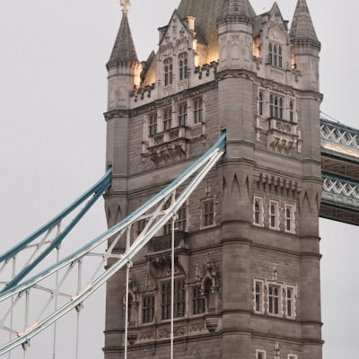 Tower Bridge stone tower illuminated against a grey sky